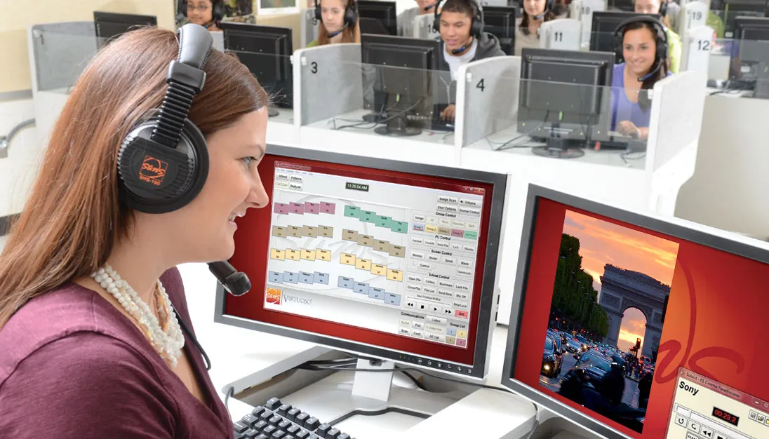 Teacher monitoring students’ progress on SANS digital language lab software in a classroom