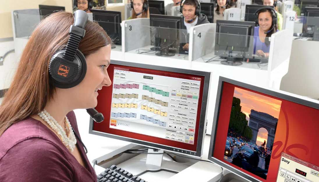 Teacher monitoring students’ progress on SANS digital language lab software in a classroom